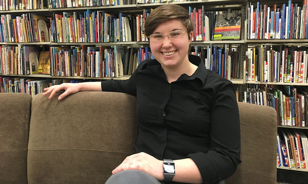 Julia Shepherd poses for a photograph outside the book shelves of King Library