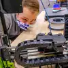 A student looks into a 3D printer.