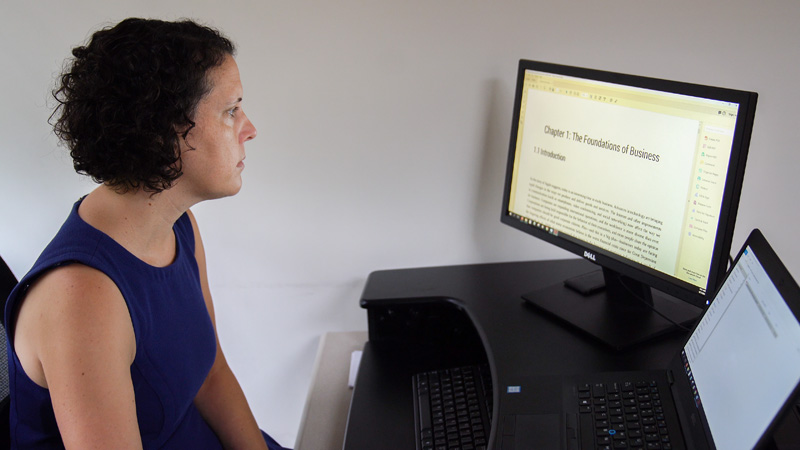 Carla Myers, scholarly communications coordinator for Miami University Libraries, views the customized open educational resource textbook she helped Business 101 instructor Cindy Oakenfull adopt.